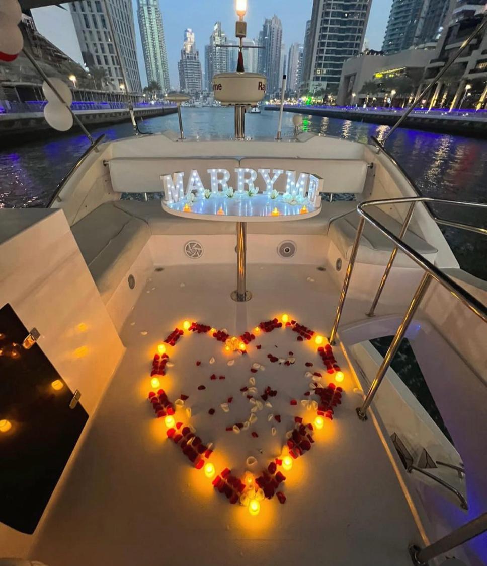 A romantic yacht proposal setup featuring a heart-shaped arrangement with marry me sign